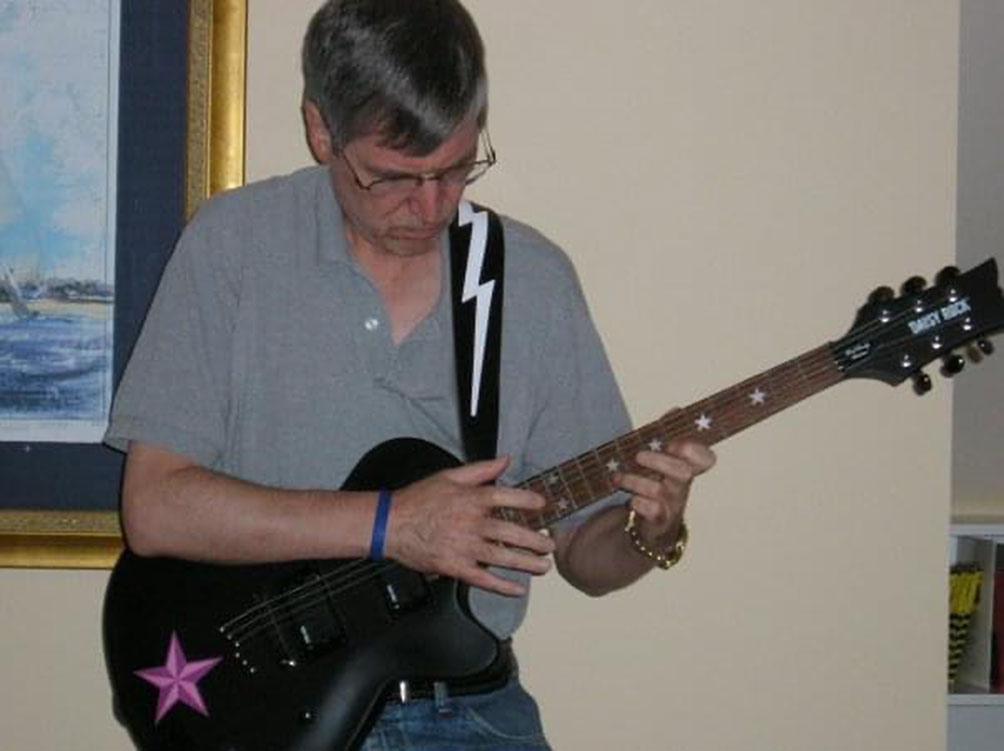 Paul is intent on figuring out a new song on his Daisy Rock guitar circa 2010.